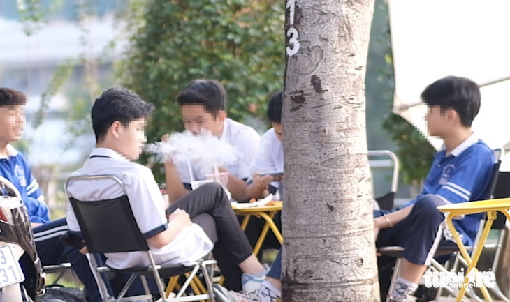 Học sinh ở TP.HCM hút thuốc lá điện tử tại một quán trên đường Đặng Thùy Trâm - Ảnh: NGỌC PHƯỢNG