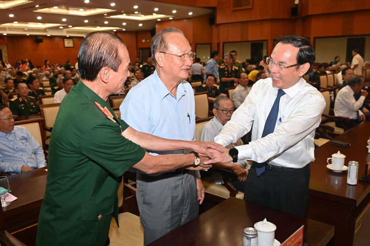Bí thư Thành ủy TP.HCM Nguyễn Văn Nên (phải) thăm hỏi các đại biểu tham gia buổi họp mặt - Ảnh: QUỐC THANH