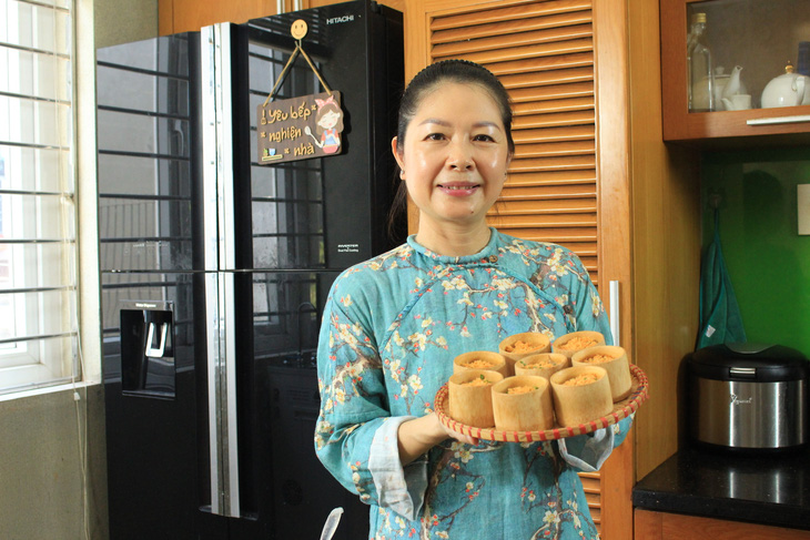 Nghệ nhân ẩm thực Kim Oanh và bánh dưa hường hấp ống tre - Ảnh: NVCC