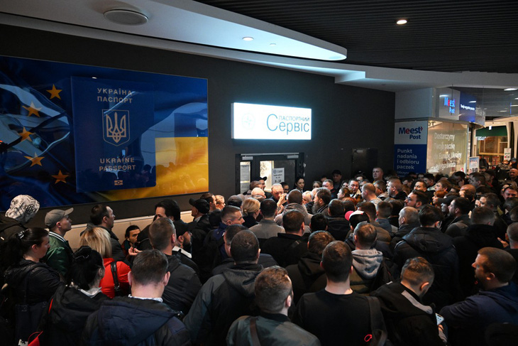 Nhiều người Ukraine tụ tập trước văn phòng cấp hộ chiếu Ukraine đã đóng cửa, trong ảnh chụp tại trung tâm mua sắm ở Warsaw, Ba Lan hôm 24-4 - Ảnh: AFP