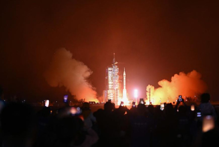 Người dân theo dõi tàu vũ trụ Thần Châu 18 được phóng lên Trạm vũ trụ Thiên Cung tối 25-4 - Ảnh: TÂN HOA XÃ