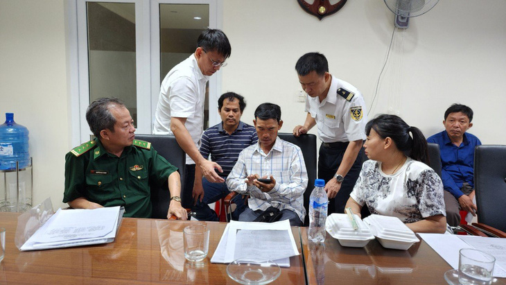 Ông Lê Văn Trung (cầm điện thoại) xác định được danh tính 3 nạn nhân, cả ba đều không có tên trong danh sách đăng ký rời cảng Kỳ Hà - Ảnh: L.Đ.