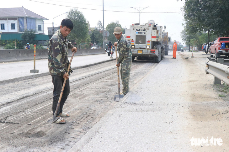 Các công nhân tham gia sửa chữa mặt đường quốc lộ 1 đoạn qua Hà Tĩnh bị hư hỏng - Ảnh: LÊ MINH