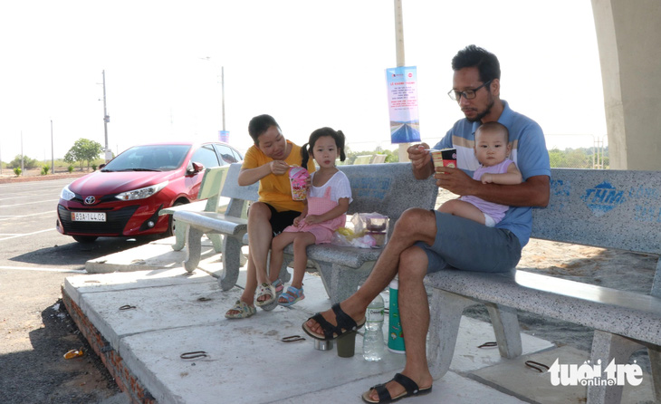 Gia đình anh Phan Văn Hoài dừng xe nghỉ ngơi tại trạm dừng nghỉ tạm đoạn qua xã Nhị Hà, huyện Thuận Nam (Ninh Thuận) - Ảnh: DUY NGỌC