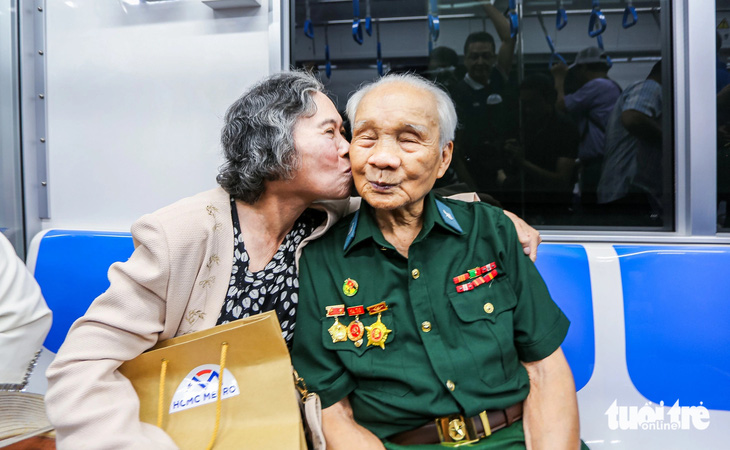 Vợ chồng ông Dương Chí Kỳ (90 tuổi, quận 7, cùng là những cựu chiến binh) trên chuyến tàu metro số 1 sáng nay - Ảnh: CHÂU TUẤN