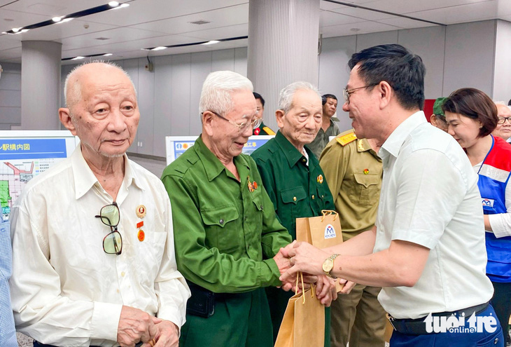Phó giám đốc Sở Thông tin và Truyền thông TP.HCM Nguyễn Ngọc Hồi hỏi thăm và tặng quà cho các cựu chiến sĩ Điện Biên tham quan tuyến metro số 1 - Ảnh: CẨM NƯƠNG