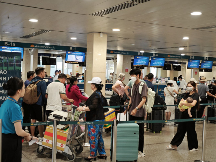 Khách xếp hàng trật tự vào khu làm thủ tục check-in của Vietnam Airlines tại Tân Sơn Nhất - Ảnh: CÔNG TRUNG