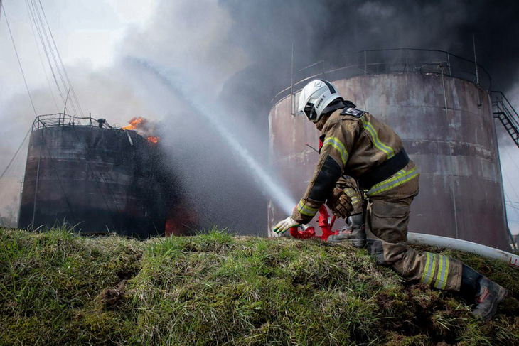Lực lượng cứu hỏa dập lửa tại một bồn chứa dầu ở khu vực Smolensk của Nga vào ngày 24-4 - Ảnh: REUTERS