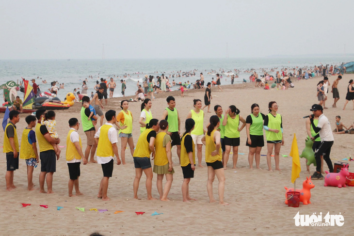 Một đoàn khách từ phía Bắc tham gia trò chơi tập thể trên biển Cửa Lò - Ảnh: DOÃN HÒA