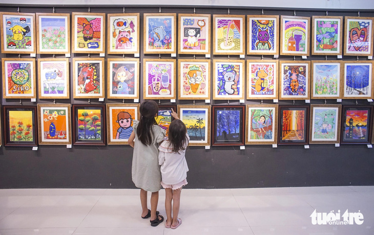 Hai em nhỏ yêu vẽ cùng dắt tay nhau chăm chú xem tranh của các bạn mình - Ảnh: H.VY