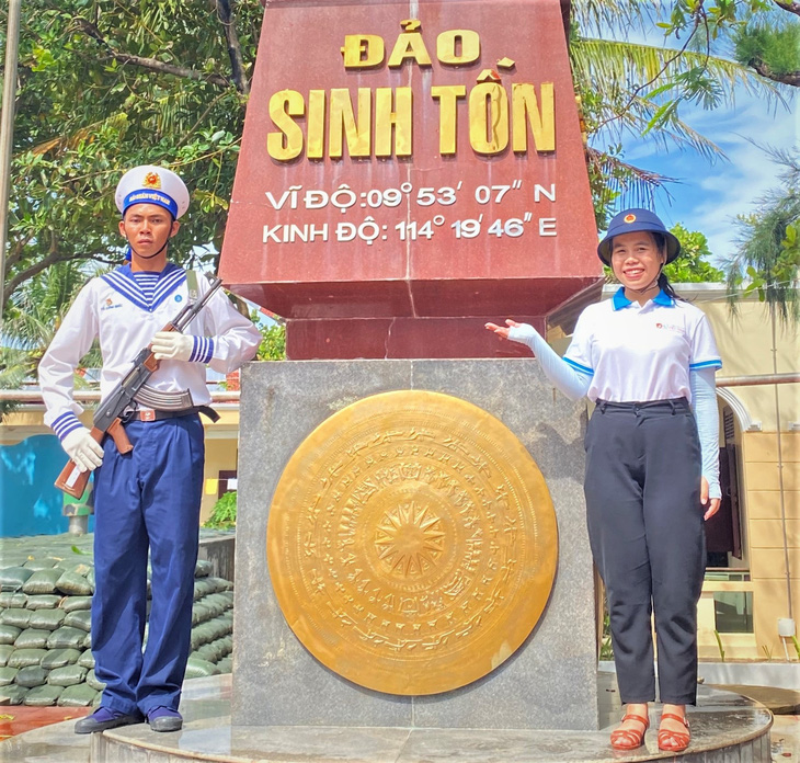 Mai Hải Yến (phải) cùng người lính gác tại đảo Sinh Tồn trong hải trình lần đầu đưa sinh viên ra thăm Trường Sa - Ảnh: NVCC