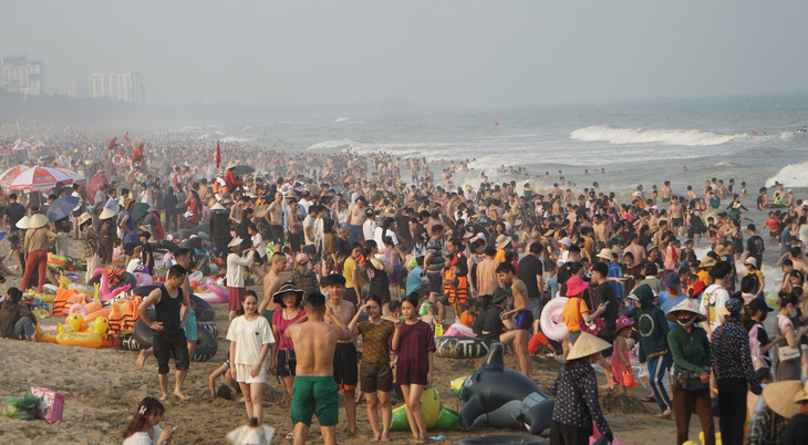 Rất đông du khách xuống bãi biển Sầm Sơn tắm giải nhiệt chiều 27-4 - Ảnh: HÀ ĐỒNG