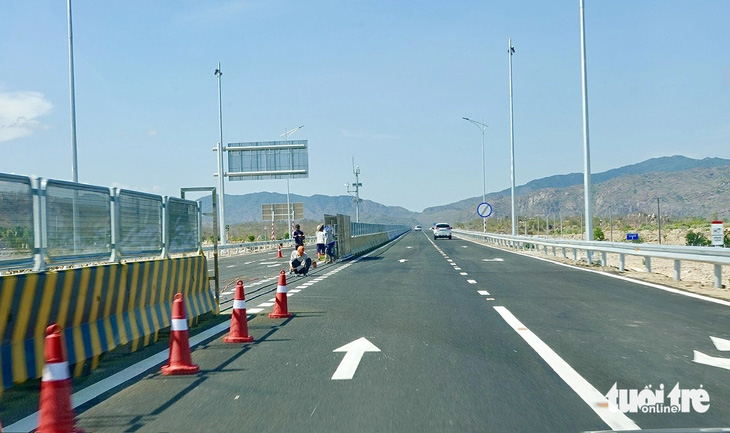Công nhân hoàn thiện hàng rào di động ngăn giữa hai hướng cao tốc Cam Lâm - Vĩnh Hảo - Ảnh: TRẦN TIẾN DŨNG