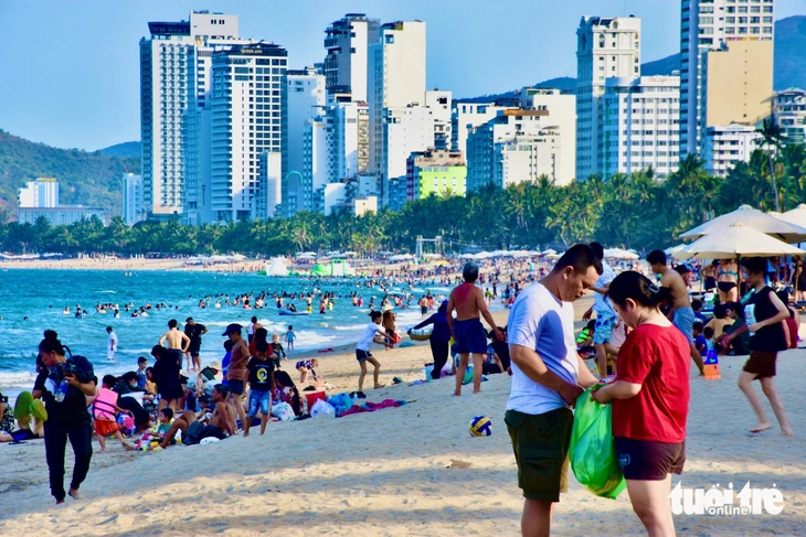 Đông nghịt người dân, du khách đổ ra biển Nha Trang để vui chơi, hóng mát, tắm biển giải nhiệt trong ngày nóng bức - Ảnh: MINH CHIẾN