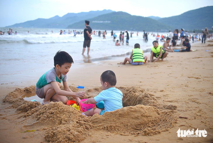 Các em nhỏ thích thú nghịch cát trên bãi biển Quy Nhơn - Ảnh: LÂM THIÊN