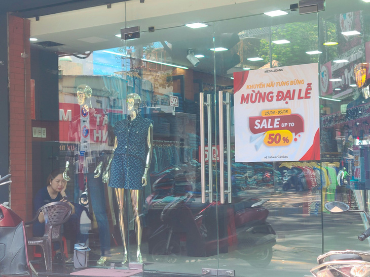 Nhiều cửa hàng thời trang trên đường Nguyễn Trãi (quận 5) vắng bóng khách giờ sáng mua dù tung khuyến mãi khủng - Ảnh: NHẬT XUÂN