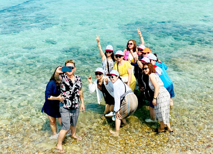 Khách du lịch vui thích chụp ảnh bên cảnh biển đảo Nam Du - Ảnh: C.CÔNG