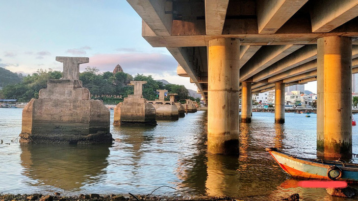 Dàn trụ cầu Xóm Bóng xưa (từ thời Pháp) bên các trụ cầu Xóm Bóng mới trên sông Cái, Nha Trang (Khánh Hòa. Ảnh chụp chiều 29-4-2024) - Ảnh: PHAN SÔNG NGÂN
