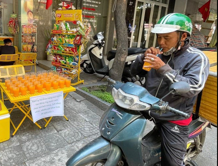 Một người chở hàng ghé uống nước cam miễn phí