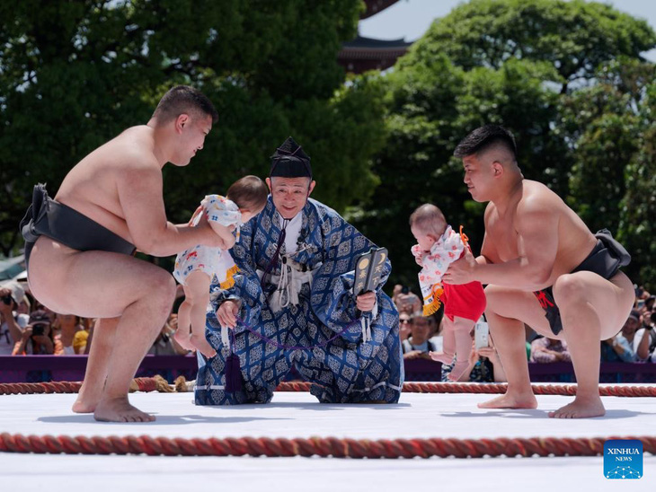 Các võ sĩ Sumo bế trẻ em trong Cuộc thi trẻ con khóc Naki Sumo ở Tokyo, Nhật Bản, hôm 28-4. Naki Sumo là nghi lễ truyền thống, được thực hiện như lời cầu nguyện cho sự phát triển khỏe mạnh - Ảnh: XINHUA