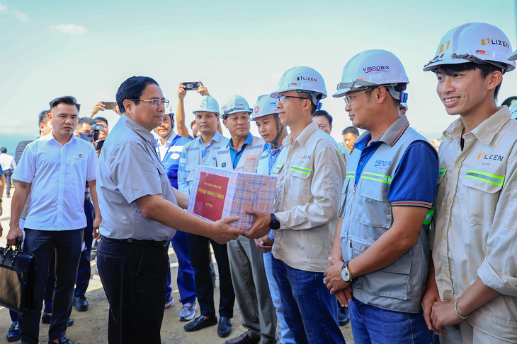 Thủ tướng Phạm Minh Chính tặng quà động viên cán bộ, công nhân trên công trường nút giao cao tốc Vân Phong - Nha Trang và Quốc lộ 26 - Ảnh: VGP