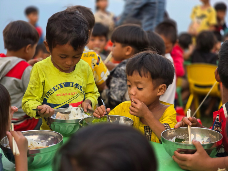 Trẻ nhỏ ở Tắk Pổ được thưởng thức bữa ăn do nhóm bạn trẻ từ Đà Nẵng lên nấu - Ảnh: NGUYỄN BÌNH NAM