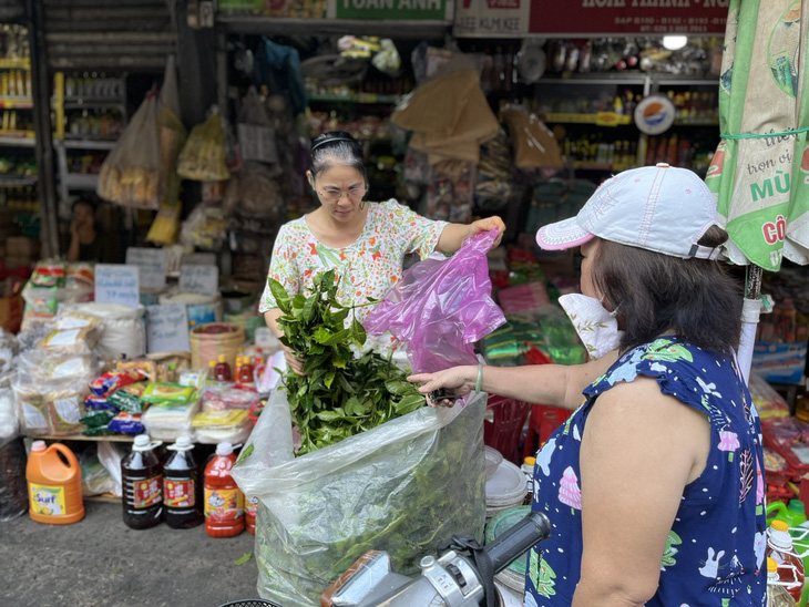 Người dân đi mua lá trà xanh ở chợ Phạm Văn Hai, quận Tân Bình, TP.HCM - Ảnh: THÙY DƯƠNG