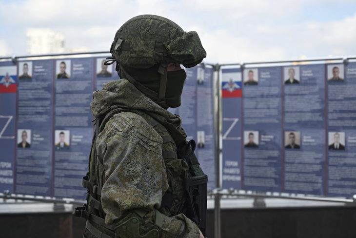 Một quân nhân Nga đứng cạnh một trung tâm tuyển quân di động  ở Rostov-on-Don, Nga, ngày 17-9-2022 - Ảnh: REUTERS