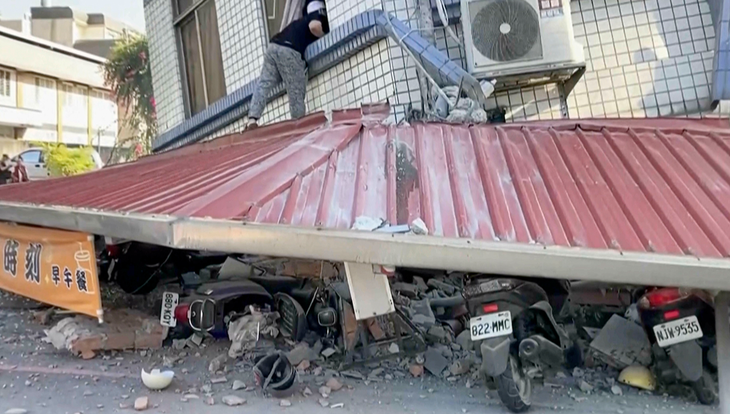 Người dân đang kiểm tra một tòa nhà đổ sập ở Đài Loan - Ảnh: TVBS