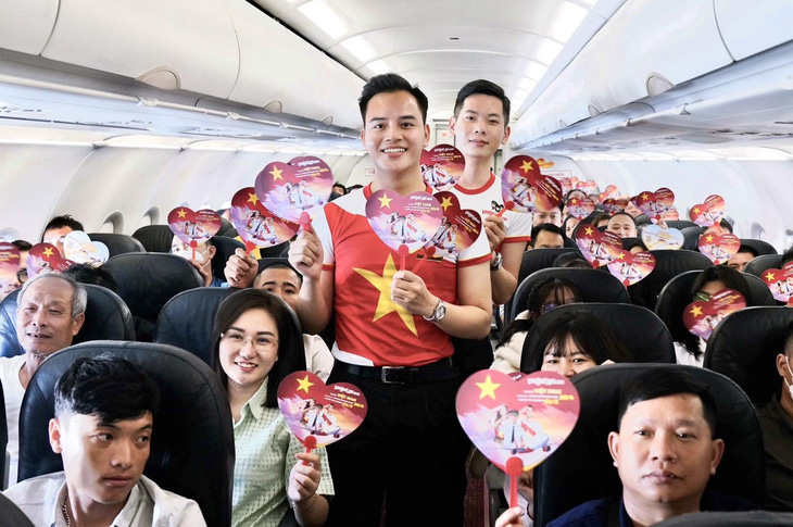 Các tiếp viên hàng không Vietjet chào đón du khách trong trang phục cờ đỏ sao vàng