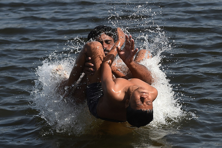 Người dân thành phố Karachi (Pakistan) tắm giải nóng trên Biển Ả Rập hôm 29-4 - Ảnh: AFP