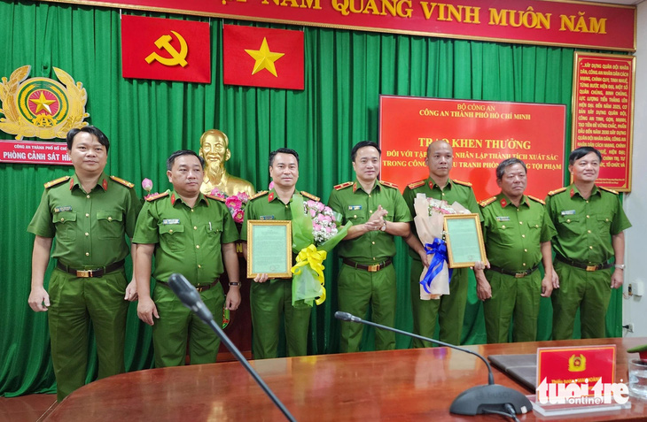 Thiếu tướng Mai Hoàng, phó giám đốc Công an TP.HCM, trao thư khen cho ban chuyên án - Ảnh: MINH HÒA