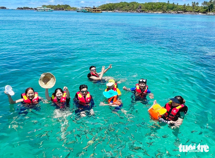 Khách du lịch ra chơi lễ 30-4 ở Phú Quốc mê tít với việc tắm biển, lặn ngắm san hô và cho đàn cá lia thia tự nhiên ăn - Ảnh: C.CÔNG