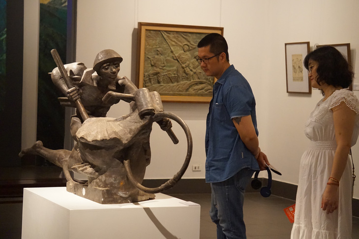 Khách xem tác phẩm điêu khắc Cả nước ra trận của Lưu Danh Thanh tại triển lãm Đường lên Điện Biên - Ảnh: T.ĐIỂU