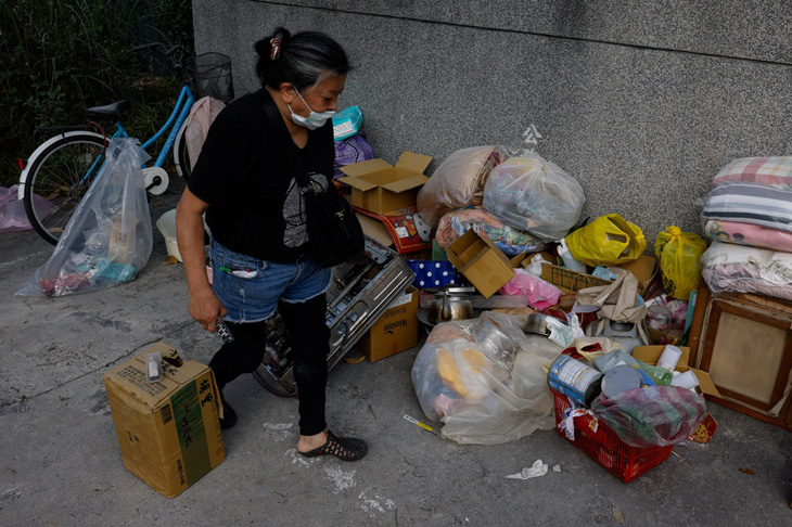 Một người phụ nữ thu dọn đồ đạc từ tòa nhà đã bị hư hại trong động đất trước khi Đài Loan tiến hành dỡ bỏ tòa nhà này - Ảnh: REUTERS