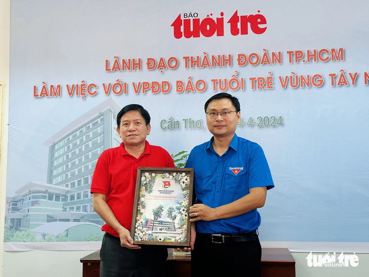 Anh Trương Minh Tước Nguyên - phó bí thư Thành Đoàn TP.HCM - tặng quà lưu niệm cho văn phòng đại diện báo Tuổi Trẻ vùng Tây Nam Bộ - Ảnh: ĐẶNG TUYẾT