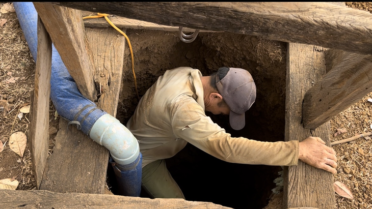 Trước khi xuống giếng sâu, thợ đào phải cẩn thận dò độ thông khí an toàn - Ảnh: TỪ SANG
