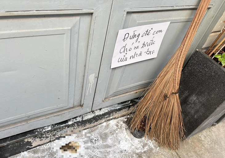 Một chủ nhà bức xúc viết cảnh cáo dán trước cửa nhà khi liên tục bị chó hàng xóm tới ị bậy ngay trước cửa nhà - Ảnh: NGÂN HÀ