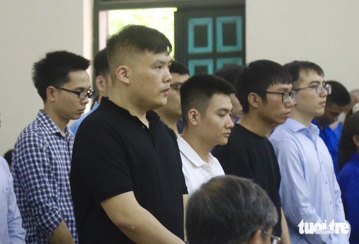 Bị cáo Nguyễn Minh Thành (áo đen, đầu tiên) cùng các bị cáo tại tòa - Ảnh: DANH TRỌNG