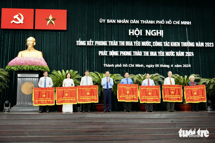 Chủ tịch UBND TP.HCM Phan Văn Mãi trao cờ thi đua của Chính phủ cho các đơn vị - Ảnh: HỮU HẠNH