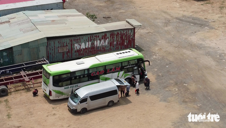 Nhà xe Cao Lâm điều xe trung chuyển chở hàng chục hành khách đến một bãi xe container, sau đó sang qua xe giường nằm ở phường Thạnh Mỹ Lợi - Ảnh: MINH HÒA
