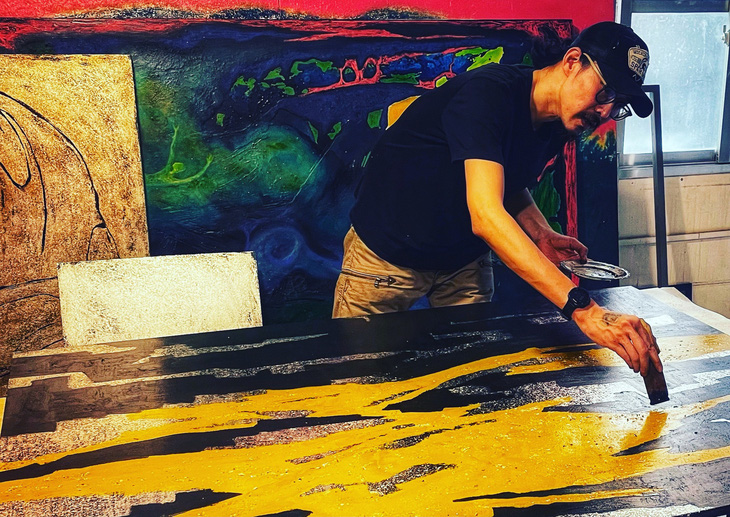 Họa sĩ Nguyễn Minh Hiếu đang sáng tạo với sơn mài trên toan - Ảnh: NVCC