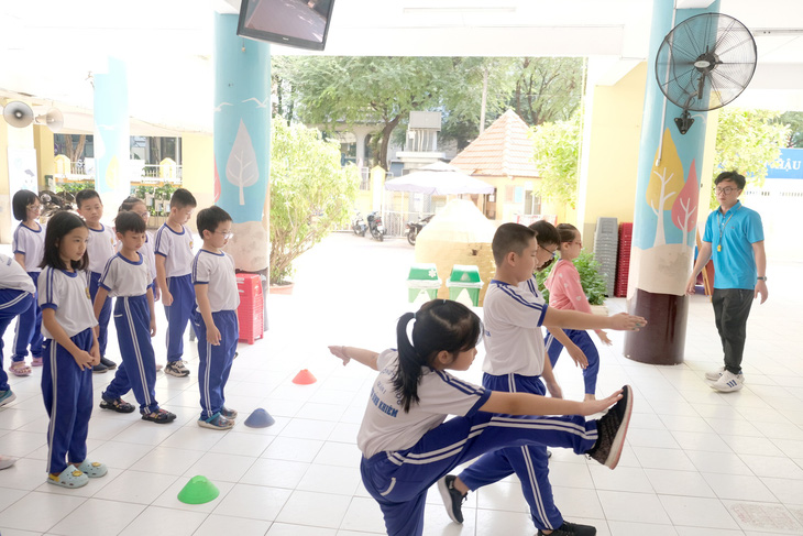 Học sinh Trường tiểu học Nguyễn Bỉnh khiêm (quận 1, TP.HCM) học thể dục dưới sảnh tòa nhà của trường để tránh nắng nóng - Ảnh: NGỌC PHƯỢNG