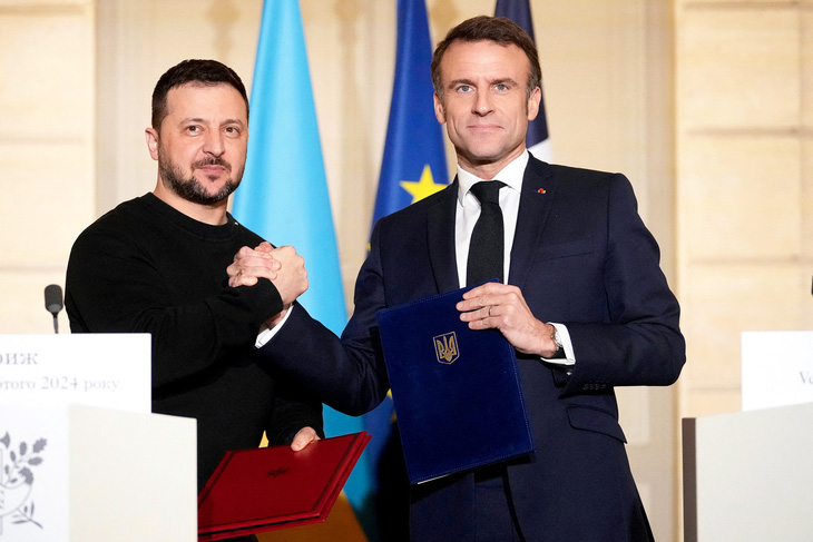Tổng thống Macron (phải) bắt tay Tổng thống Ukraine Zelensky sau khi hai bên ký Hiệp định an ninh song phương tại Điện Elysee tháng 2-2024 - Ảnh: AFP