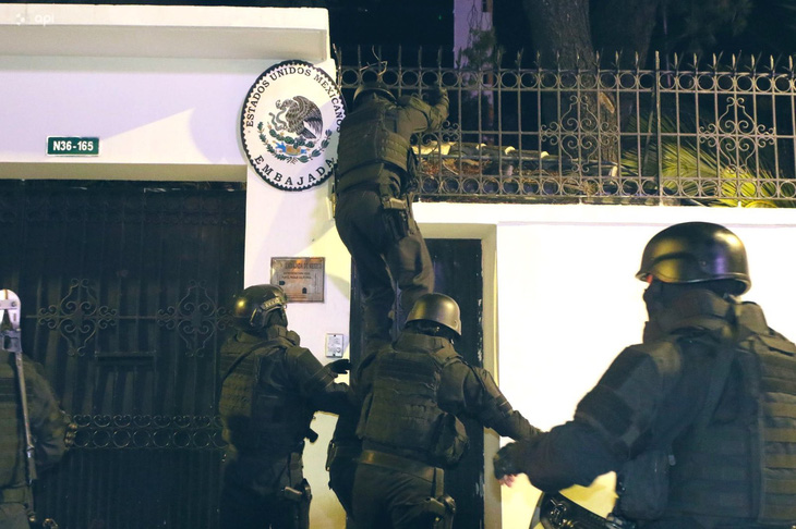 Đặc nhiệm Ecuador trèo hàng rào để vào trong Đại sứ quán Mexico bắt ông Jorge Glas hôm 5-4 - Ảnh: AFP