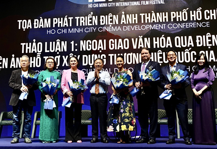 Các diễn giả khách mời nhận hoa từ ông Dương Anh Đức, phó chủ tịch UBND TP.HCM - Ảnh: T.T.D