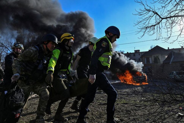 Các nhân viên cấp cứu khiêng một người phụ nữ bị thương sau một cuộc tấn công của Nga ở Zaporizhzhia, Ukraine, ngày 5-4 - Ảnh: REUTERS