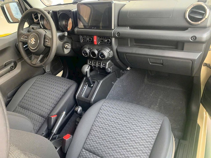 Nội thất Suzuki Jimny khá đơn giản so với mức giá khoảng 800 triệu đồng. Đồng hồ dạng analog kết hợp màn hình đơn sắc. Màn hình trung tâm kích thước 7 inch dạng nổi. Núm chỉnh điều hòa dạng xoay giống trên Swift. Xe có 4 chỗ ngồi và do chỉ có 3 cửa, người ngồi sau phải đi vào xe qua cửa trước - Ảnh: Đại lý Suzuki