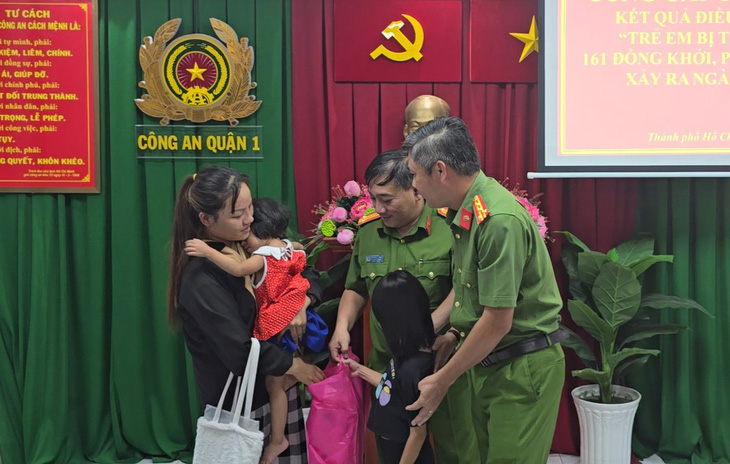 Công an TP.HCM trao trả hai cháu cho chị Nguyễn Thị Chi - Ảnh: ĐAN THUẦN