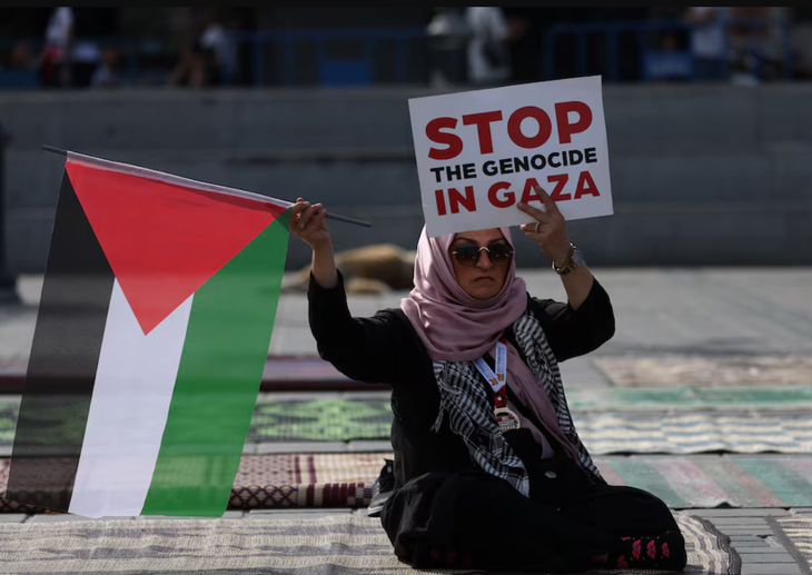 Một người phụ nữ cầm cờ Palestine và biểu ngữ với nội dung ủng hộ người Palestine ở Gaza tại thành phố Istanbul, Thổ Nhĩ Kỳ vào tháng 10-2023 - Ảnh: REUTERS